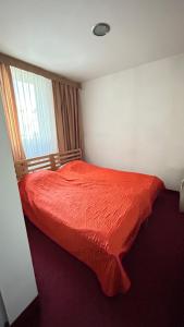 a bedroom with a red bed with a window at Motel Tiron in Kakanj