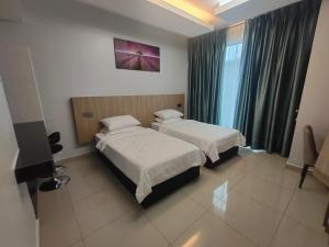 Habitación de hotel con 2 camas y TV en Alish Studio Apartment with Pool, Netflix, Wifi, en Gua Musang