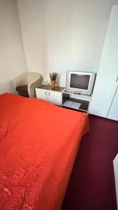 a bedroom with a bed and a desk with a tv at Motel Tiron in Kakanj