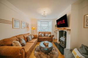 uma sala de estar com dois sofás e uma lareira em Spacious Heart of town w/garden WiFi Smart TV em Cirencester