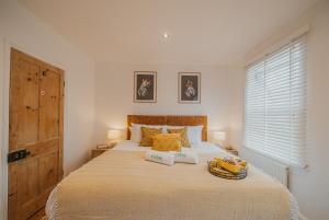 een slaapkamer met een groot bed met 2 kussens bij Spacious Heart of town w/garden WiFi Smart TV in Cirencester