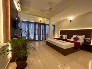 1 dormitorio con 1 cama y TV. en The Ocean Park Beach Resort, en Kovalam