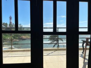 una ventana con vistas a la playa en The Ocean Park Beach Resort, en Kovalam