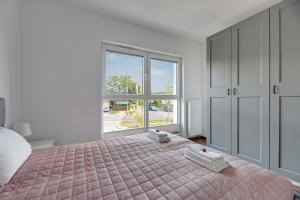 a bedroom with a bed and a large window at Apartment Brzeźno Beach by TriApart in Gdańsk