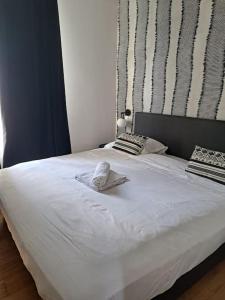 uma grande cama branca com um chapéu em Au centre de paris - 4pax em Paris