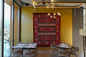 a dining room with two tables and a red rug on the wall at Hotel Uji Ftohte Tepelene in Tepelenë +225 photos