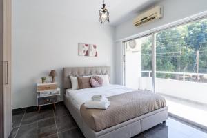 una camera con un letto e una grande finestra di Powder’s 1-Bedroom Retreat in Mackenzy, Larnaca a Larnaka