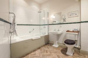 uma casa de banho com uma banheira, um WC e um lavatório. em The White Swan Inn em Pickering