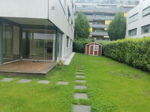 einen Hinterhof mit Rasen mit rotem Haus in der Unterkunft Wunderschöner Aufenthaltsort in Bregenz