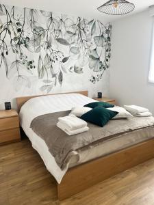 um quarto com uma cama com um mural floral na parede em Maison 4/6 personnes à Bayeux em Bayeux