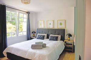 1 dormitorio con 1 cama blanca grande y ventana en NEW Remodeled Home 4Bed/3.5Bath, Walking to BEACH!, en Saint-Lunaire