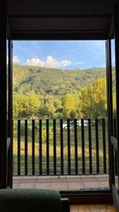 une pièce avec une grande fenêtre avec vue sur une montagne dans l'établissement Apartamentos Nogueret, à Benasque 13 autres photos