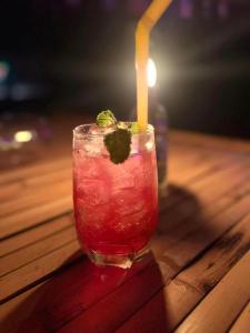 a drink sitting on a wooden table with a candle at Green smile camping and private beach in Krabi