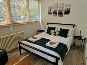 - une chambre avec un lit et 2 serviettes dans l'établissement 2 Bedroom flat in great location!, à Londres