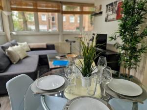 una mesa de comedor con platos y copas de vino. en 2 Bedroom flat in great location!, en Londres