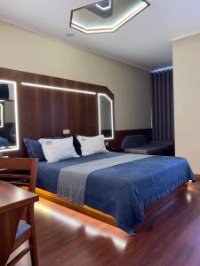 sypialnia z dużym łóżkiem z drewnianym zagłówkiem w obiekcie Motel Paraíso do Braseiro w mieście Vila Nova de Gaia