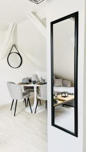 a mirror in a room with a table and a dining room at K-Business-Apartments in Oberesslingen