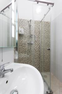 een badkamer met een wastafel en een douche bij Tarona Guesthouse in St Paul's Bay
