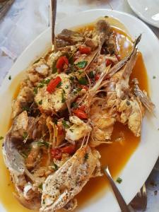 une assiette de nourriture avec des crevettes dans une sauce dans l'établissement Hotel Il Pirata, à Cinisi