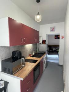 茹瓦尼的住宿－Le Mustang Internet Fibre Netflix，一间厨房,配有红色橱柜和台面