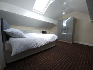 a bedroom with a white bed and a mirror at Stylish property near town centre in Tyldesley
