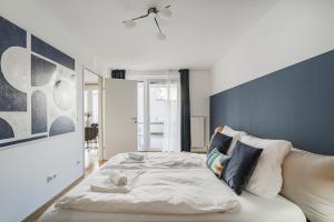 a bedroom with a large bed with a blue wall at Modern Living Apartments Vienna, 15 min to center in Vienna