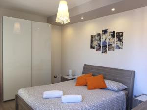 1 dormitorio con 1 cama con 2 almohadas de color naranja en Terra di Sicilia, en Avola