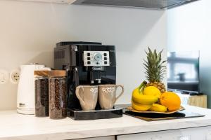 a coffee maker sitting on a counter with fruit at Tempus Te Premium Duo Lofts Tartu - private cinema, gym and terrace in Tartu