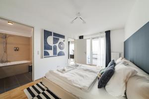 a bedroom with a large bed and a bathroom at Modern Living Apartments Vienna, 15 min to center in Vienna