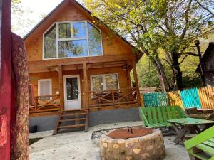 a cabin in the woods with a table and chairs at Wooden House Kopiti in Tbilisi City