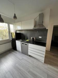 a kitchen with white cabinets and a counter top at MG15 Schönes Maisonette Apartment in schöner Lage in Mönchengladbach