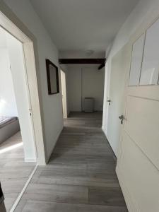 an empty hallway with white walls and wood floors at MG15 Schönes Maisonette Apartment in schöner Lage in Mönchengladbach