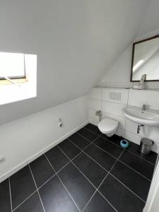 ein weißes Bad mit einem Waschbecken und einem WC in der Unterkunft MG15 Schönes Maisonette Apartment in schöner Lage in Mönchengladbach