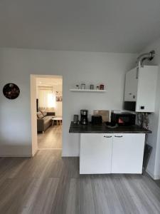 a kitchen with white cabinets and a living room at MG15 Schönes Maisonette Apartment in schöner Lage in Mönchengladbach