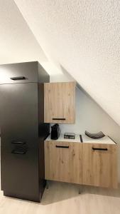 K-Business-Apartments في Oberesslingen: مطبخ مع ثلاجة ستانلس ستيل بجوار سقف