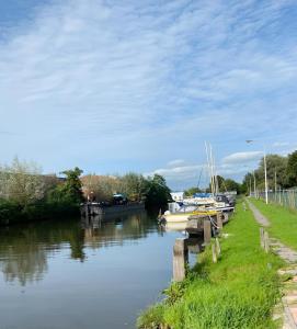 un río con barcos atracados junto a un muelle en Woonboot in Sumar gelegen tussen Leeuwarden en Drachten, en Suameer