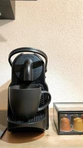 a coffee maker with a cup inside of it at K-Business-Apartments in Oberesslingen