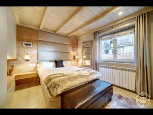 Un dormitorio con una cama grande y una ventana. en SANGLIER de Alma de Nieve, en Naut Aran (Alto Arán)