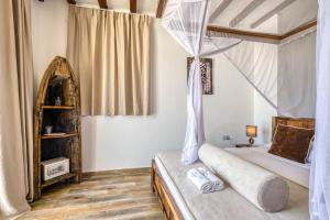 a bedroom with a bed with a canopy at Cinnamon Hotel in Jambiani
