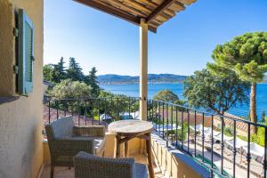 a balcony with a table and chairs and a view of the water at La Bastide d'Antoine in Saint-Tropez