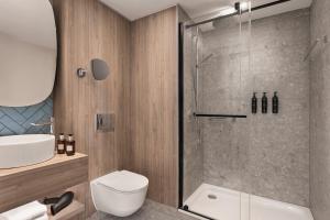uma casa de banho com um chuveiro, um WC e um lavatório. em Residence Inn by Marriott Vienna City East em Viena