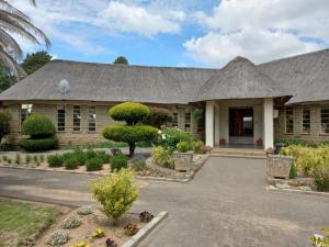 a house with a thatched roof at Mmelesi Lodge in Maseru