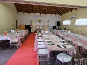 a large banquet hall with long tables and chairs at Mmelesi Lodge in Maseru