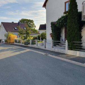 een wit hek aan de zijkant van een huis bij Ferienwohnung RELAX in Neudrossenfeld