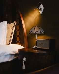 a lamp on a table next to a bed at Sommerro in Oslo