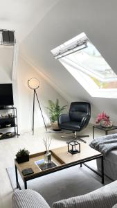 uma sala de estar com uma clarabóia e uma cadeira preta em K-Business-Apartments em Oberesslingen