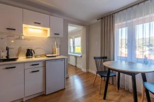 a kitchen and dining room with a table and chairs at Apartamenty „Nad Popradem” in Rytro