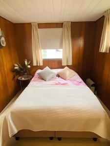 een slaapkamer met een groot bed en een raam bij Woonboot in Sumar gelegen tussen Leeuwarden en Drachten in Suameer