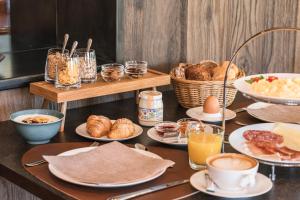 a table with breakfast foods and drinks on it at Boutique Hotel Planlim in Ortisei