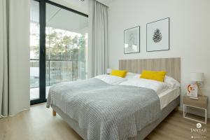 a bedroom with a bed and a large window at Shellter Apartments 117 K - by Jantar Apartamenty in Rogowo